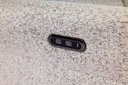 Nahaufnahme einer strukturierten Stoffoberfläche mit integrierter Bedieneinheit und USB-Anschluss, seitliche Perspektive.