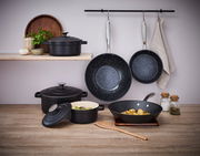 Wokpfanne 28cm, schwarz, in einer modernen Küchenszene, von vorne betrachtet, mit weiteren Kochutensilien und Gewürzen im Hintergrund.