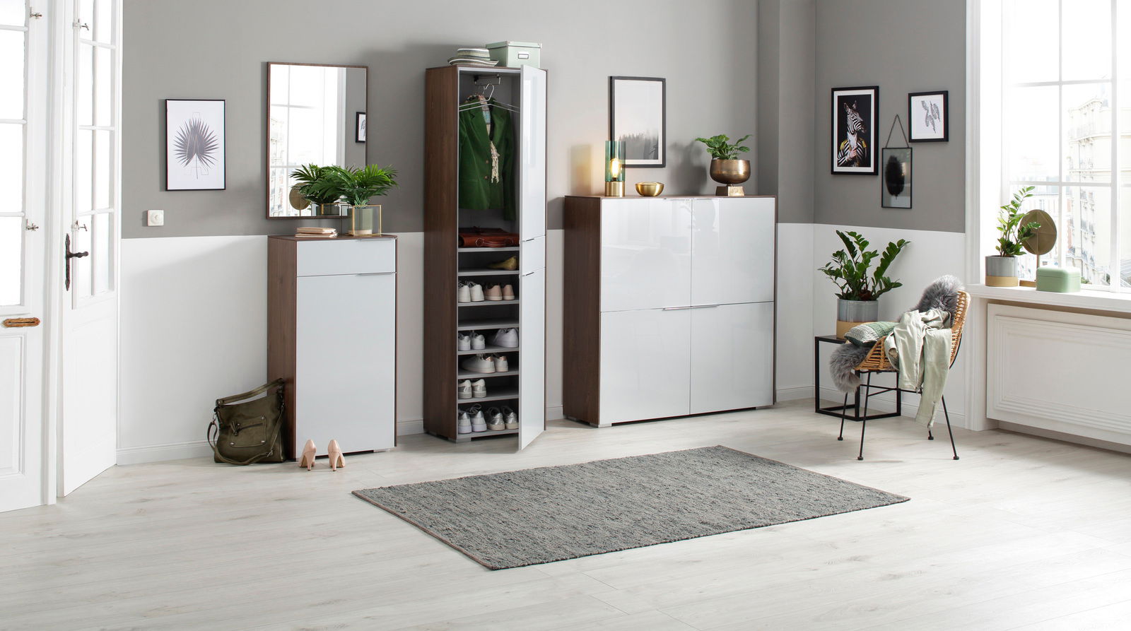 Moderne Garderobeneinrichtung mit Schuhschränken, Spiegel und Pflanzen in einem hellen Raum, seitliche Perspektive.