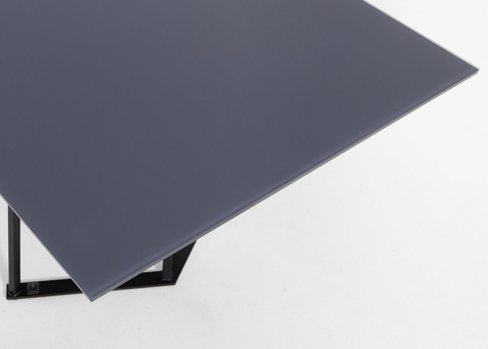 Moderner Esstisch mit dunkler Tischplatte und Metallgestell, aus der Vogelperspektive fotografiert.