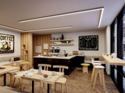 Moderner Café-Innenraum mit hellen Holztischen und Barhockern, Theke mit Espressomaschine und Regal, warmen LED-Deckenlinien sowie Menütafel an der Wand, aufgenommen aus leicht erhöhter, schräger Perspektive von der Sitzbereich-Seite in Richtung Theke und