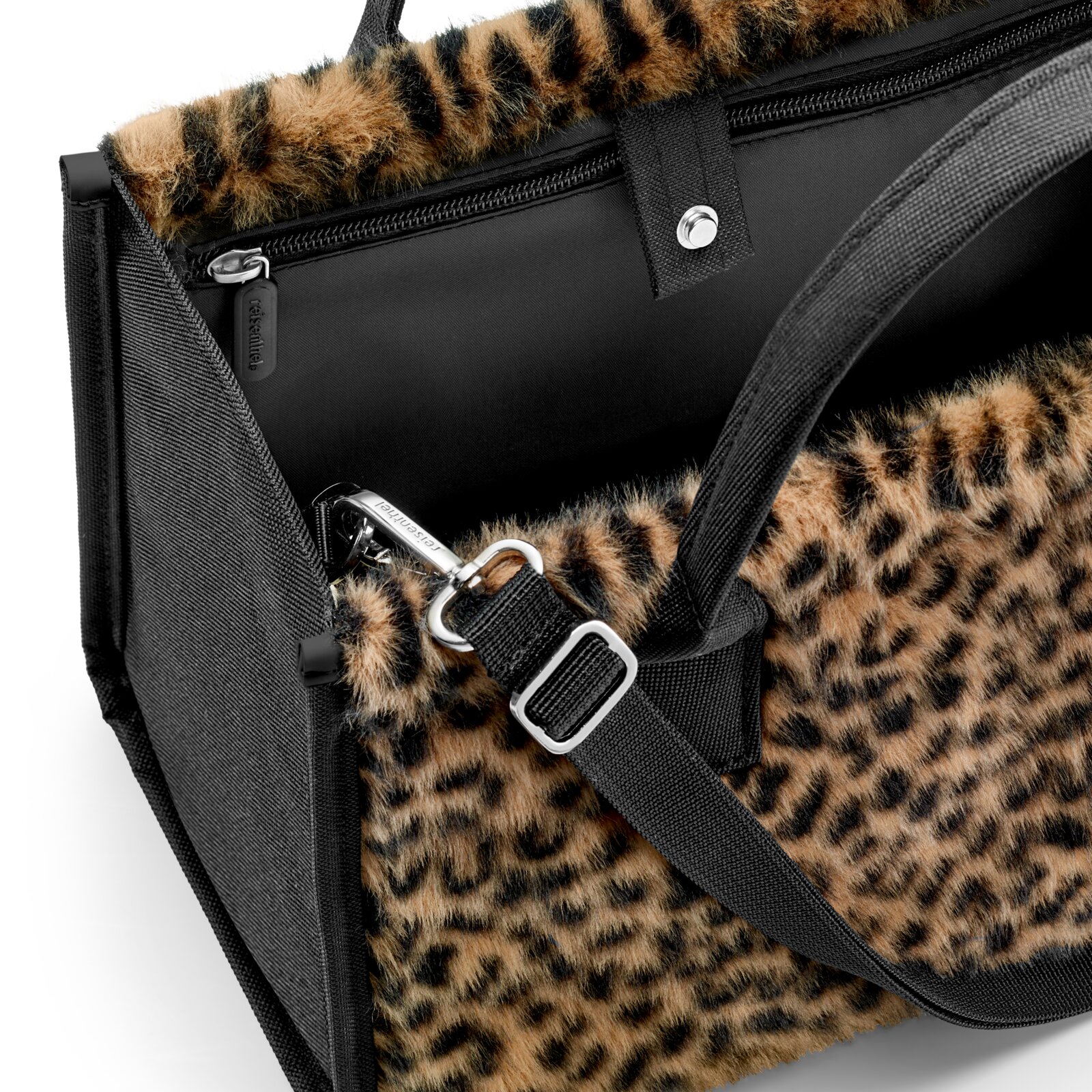 Detailansicht aus seitlicher Perspektive: Leopardmuster-Tasche mit schwarzem Reißverschlussfach, Tragegriffen und verstellbarem Schultergurt mit Metallkarabinern