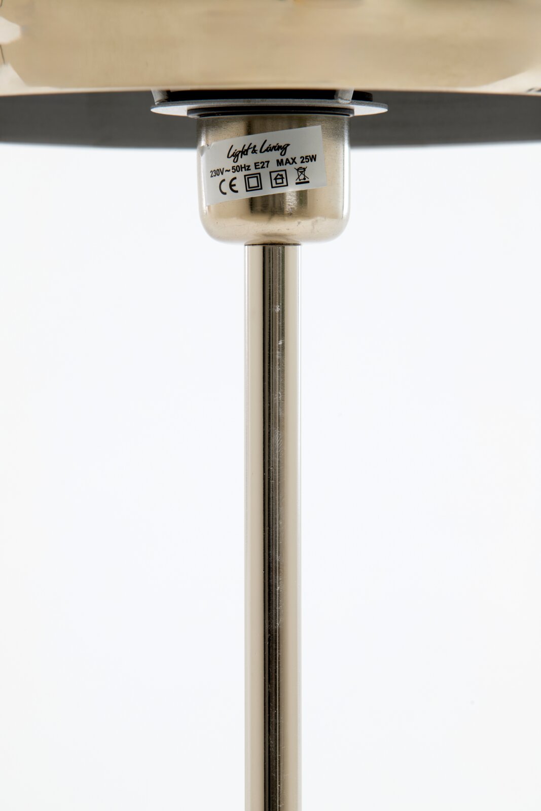 Nahaufnahme einer Tischleuchte von unten, die den Sockel und den Stab zeigt, mit einem Etikett, das technische Details enthält.
