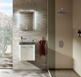 Modernes Gästebad mit beleuchtetem Spiegel, Waschbeckenunterschrank und Regendusche, seitliche Perspektive.