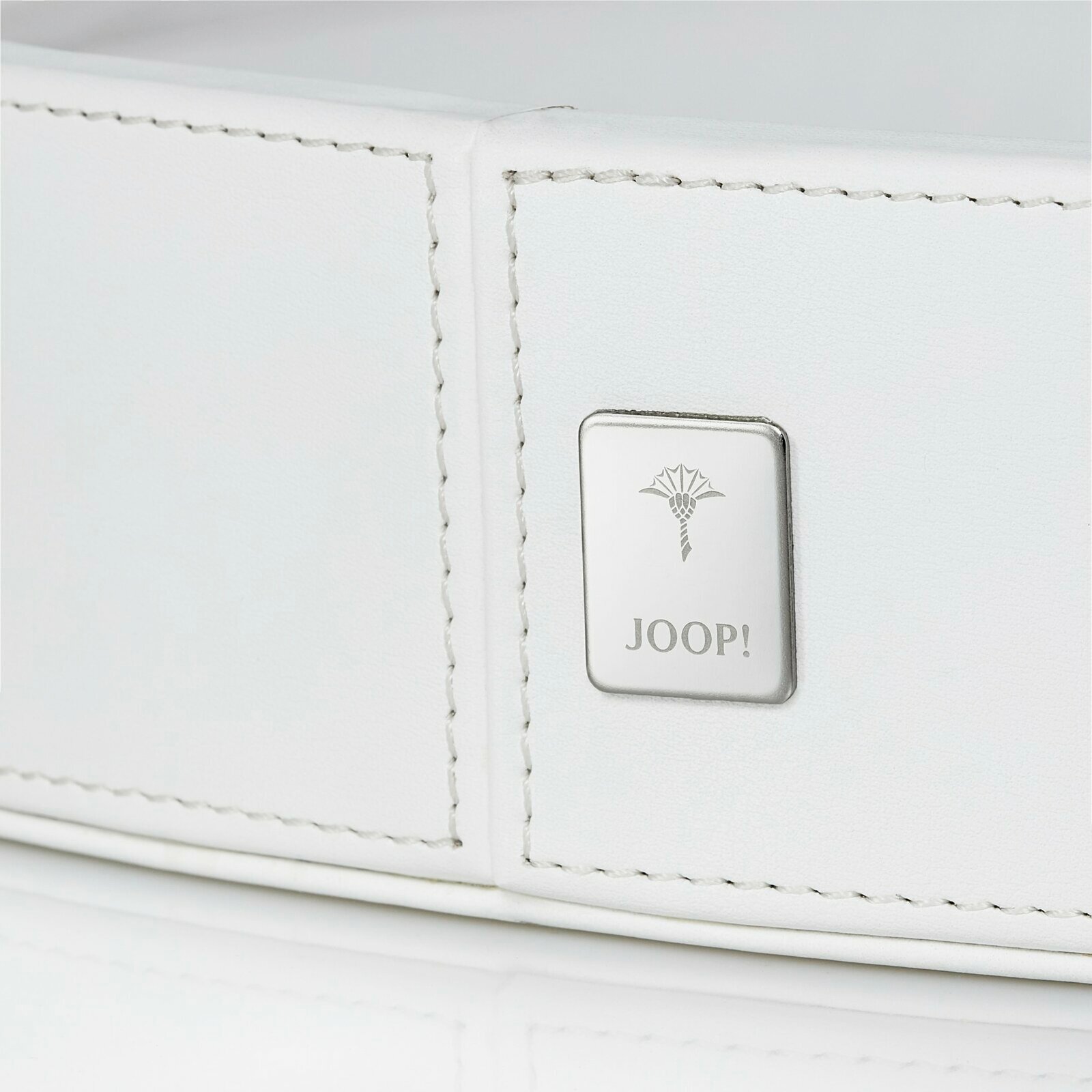 Nahaufnahme eines großen, weißen, runden Tabletts mit einem silbernen Joop!-Logo auf der Seite.