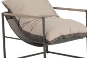 Nahaufnahme eines Lounge-Sessels mit beigem Kissen und Metallrahmen, seitliche Perspektive