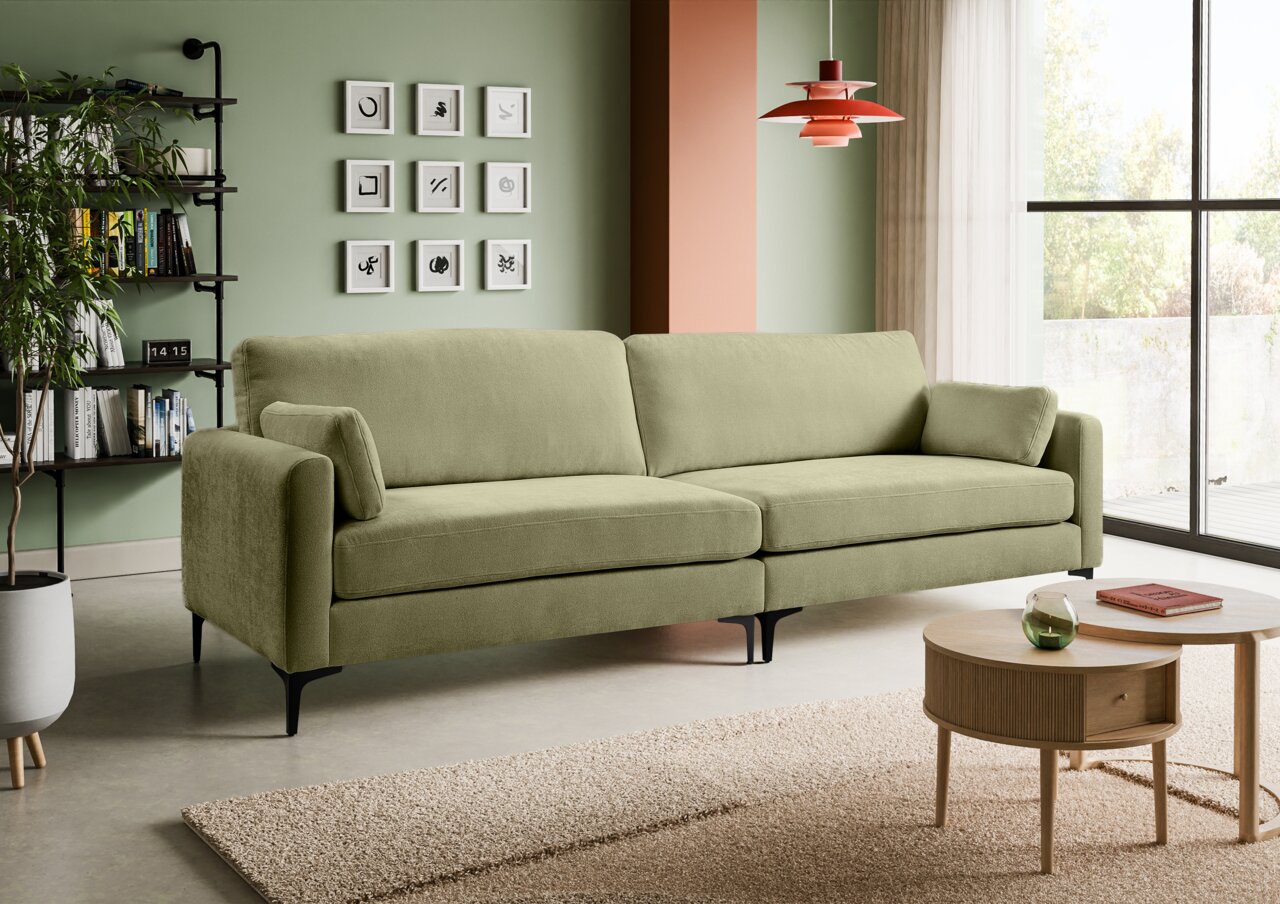 Olivgrünes 3-Sitzer-Sofa mit Stoffbezug, breiten Armlehnen, zwei Rückenkissen und schwarzen Metallfüßen im modernen Wohnzimmer Perspektive: frontale, leicht seitliche Ansicht von links.