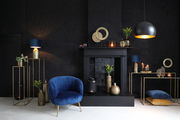 Elegantes Wohnzimmer mit modernem Dekor, darunter ein blaues Samtsofa, goldene Vasen und ein schwarzer Kamin. Perspektive: Frontalansicht.