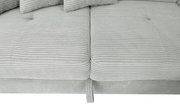 Nahaufnahme einer hellgrauen, gerippten Stoffoberfläche eines Sofas mit Kissen, von oben betrachtet.