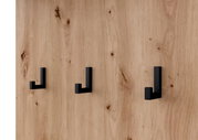 Nahaufnahme einer Holzwand mit drei schwarzen Haken in moderner, minimalistischer Gestaltung.