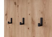 Nahaufnahme einer Holzwand mit drei schwarzen Haken in moderner, minimalistischer Gestaltung.
