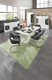 Moderne Esszimmermöbel in einem stilvollen Raum mit großen Fenstern, bestehend aus einem weißen Tisch, grauen Stühlen und weißen Vitrinen. Perspektive: Blick von oben auf den Essbereich.