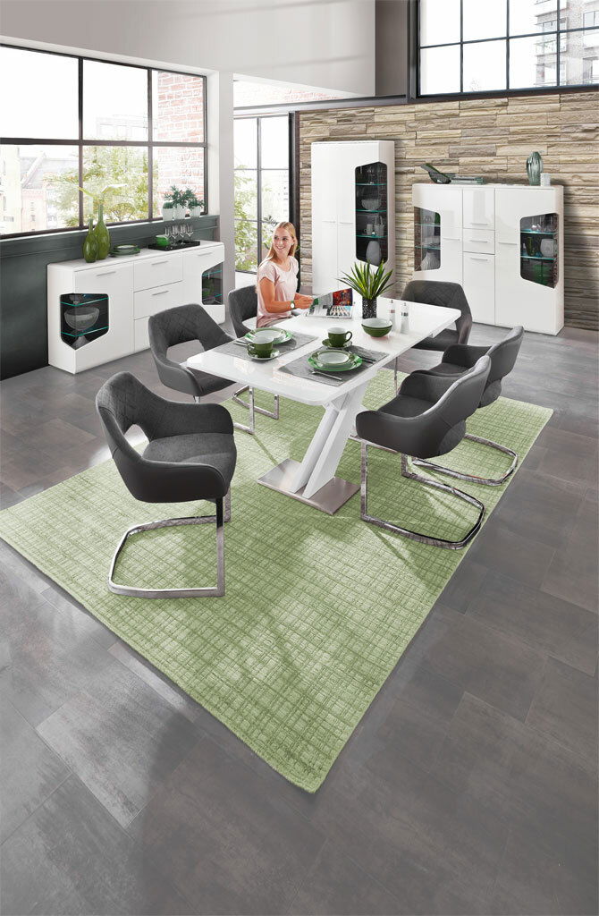 Moderne Esszimmermöbel in einem stilvollen Raum mit großen Fenstern, bestehend aus einem weißen Tisch, grauen Stühlen und weißen Vitrinen. Perspektive: Blick von oben auf den Essbereich.