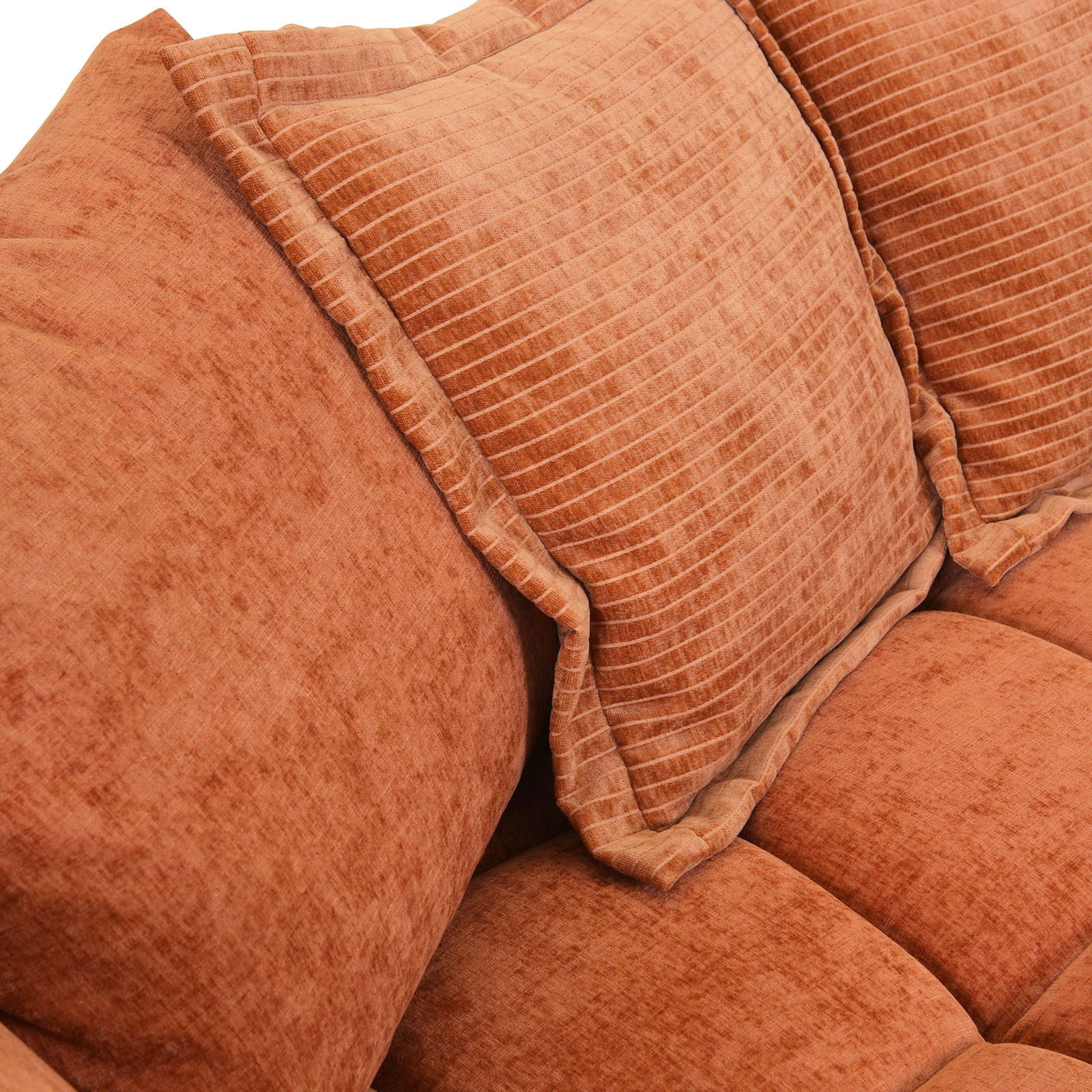 Nahaufnahme eines orangefarbenen Big-Sofas mit strukturierten Kissen.