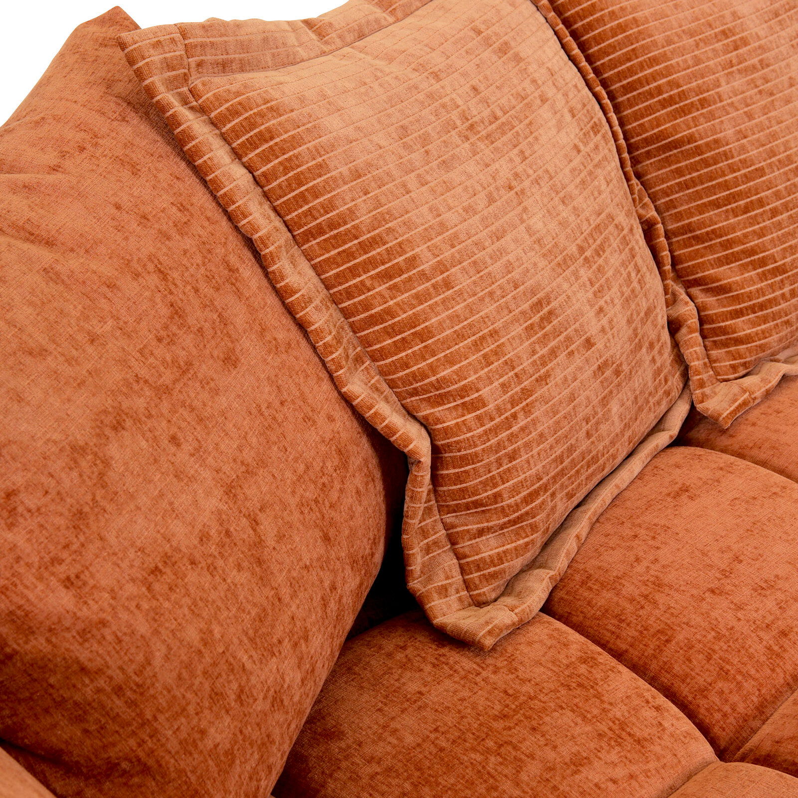 Nahaufnahme eines orangefarbenen Big-Sofas mit strukturierten Kissen.