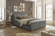 Gemütliches Boxspringbett in modernem Schlafzimmer, seitliche Perspektive