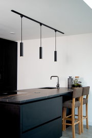 Moderne schwarze Pendelleuchte FLORIS über einer Kücheninsel, seitliche Perspektive