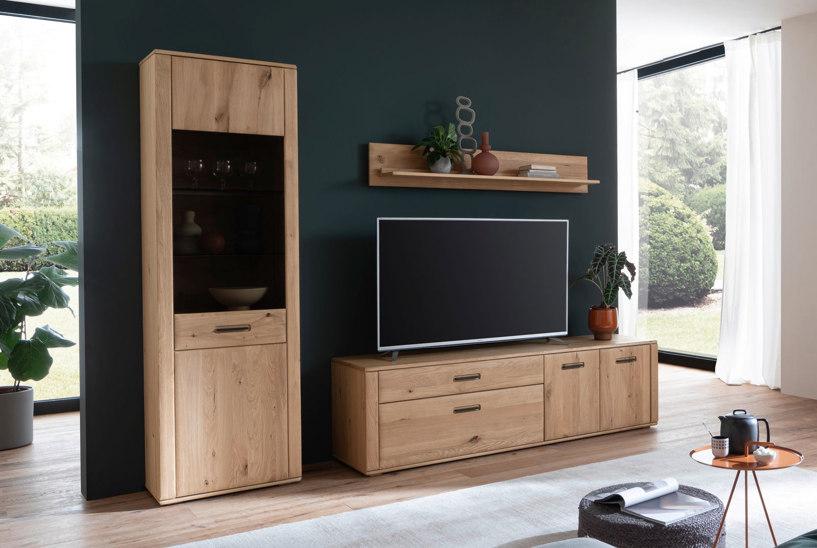 Moderne Wandkombination aus Holz mit Vitrine, TV-Board und Wandregal in einem stilvollen Wohnzimmer, seitliche Perspektive