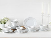 Elegantes 18-teiliges weißes Kaffeeservice mit Tassen, Untertassen und Tellern, stilvoll arrangiert auf einem Tisch mit Blumen und Kerzen, aus seitlicher Perspektive fotografiert.