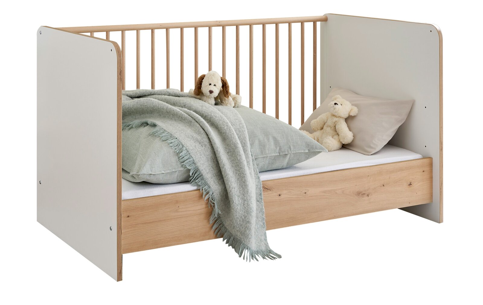 MyBaby Umbauseiten 2er Set ASTEA Modernes Kinderbett in Weiß und Naturholz mit Gitterseite, bezogen mit Bettwäsche und Kuscheltieren, freigestellt vor weißem Hintergrund, schräg von vorne links fotografiert.