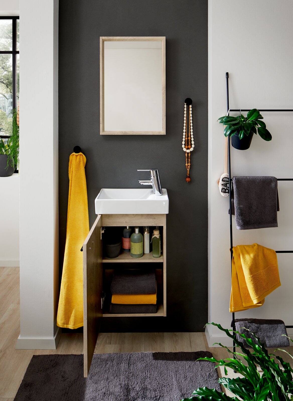 Modernes Badezimmer-Waschtischset mit weißem Keramikbecken, Holz-Unterschrank mit geöffneter Tür und Spiegel über dem Waschbecken, frontal aus Augenhöhe fotografiert.