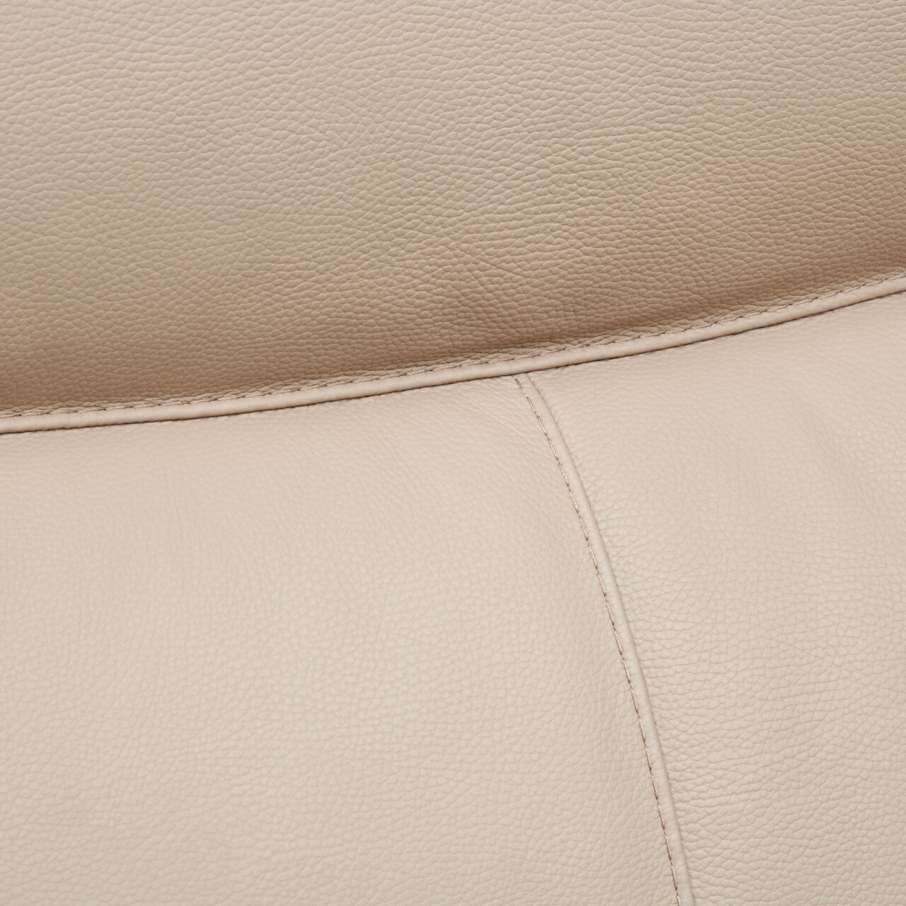 Nahaufnahme einer beigen Lederpolsterung mit sichtbaren Nähten, perspektivisch von oben.