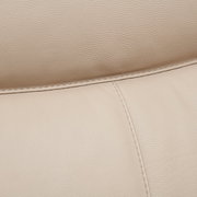 Nahaufnahme einer beigen Lederpolsterung mit sichtbaren Nähten, perspektivisch von oben.