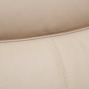 Nahaufnahme einer beigen Lederpolsterung mit sichtbaren Nähten, perspektivisch von oben.