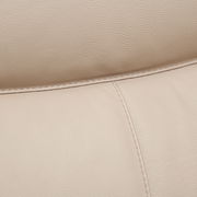 Nahaufnahme einer beigen Lederpolsterung mit sichtbaren Nähten, perspektivisch von oben.