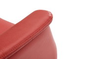 Close-up van een rode leren relaxfauteuil, met de nadruk op de armleuning, gezien vanuit de zijkant
