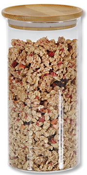 Aufbewahrungsglas mit Holzdeckel, gefüllt mit Müsli, aus der Frontalperspektive.