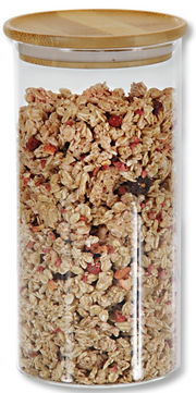 Aufbewahrungsglas mit Holzdeckel, gefüllt mit Müsli, aus der Frontalperspektive.