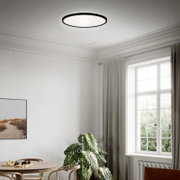 Moderne LED-Deckenleuchte in einem stilvollen Wohnzimmer, von unten betrachtet.