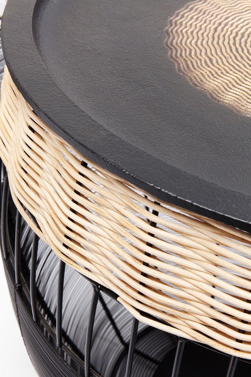 Nahaufnahme eines Beistelltischs mit schwarzer Tischplatte und geflochtenem Rattangestell, seitliche Perspektive.