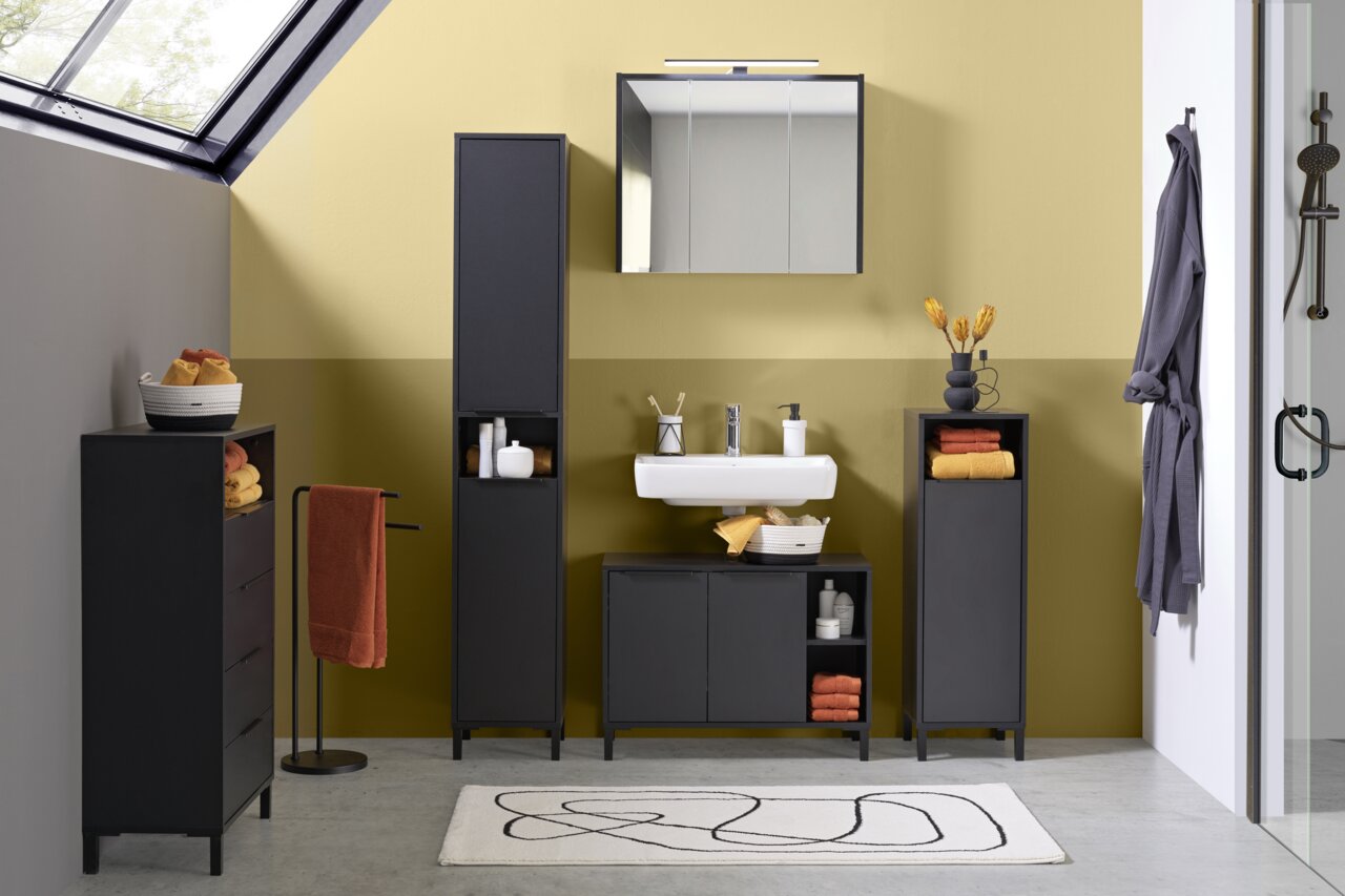 Moderner Badezimmerbereich mit Waschbeckenunterschrank in dunklem Design, frontal betrachtet. Der Raum ist stilvoll mit passenden Schränken und Accessoires dekoriert.