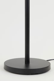 Nahaufnahme des Sockels einer schwarzen Stehleuchte mit rundem Fuß, seitliche Perspektive.