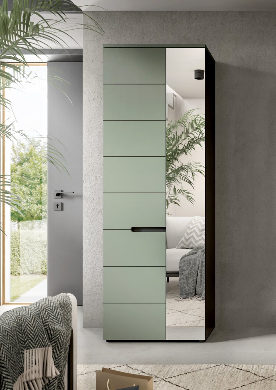 Moderner Kleiderschrank mit mattgrüner Front und vertikaler Spiegeltür, schwarzem Griff und Korpus, im Wohnzimmer platziert; Perspektive: frontale Ansicht mit leichter Rechtsansicht.