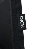 Nahaufnahme eines schwarzen Stoffes mit einem Etikett der Marke 'xora', seitliche Perspektive.