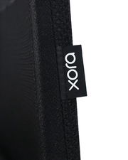 Nahaufnahme eines schwarzen Stoffes mit einem Etikett der Marke 'xora', seitliche Perspektive.