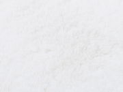 Nahaufnahme eines weißen Fellteppichs mit weicher Textur