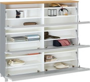 Weißes Schuhregal/Sideboard mit Holzplatte und drei nach unten klappbaren Fronten, geöffnet mit mehreren Fächern und Gasdruckdämpfern, befüllt mit Schuhen und Accessoires, Frontansicht leicht schräg von oben