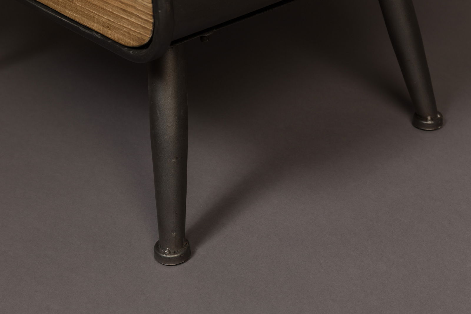 Nahaufnahme eines Weinregals mit Metallbeinen und Holzdetails, seitliche Perspektive