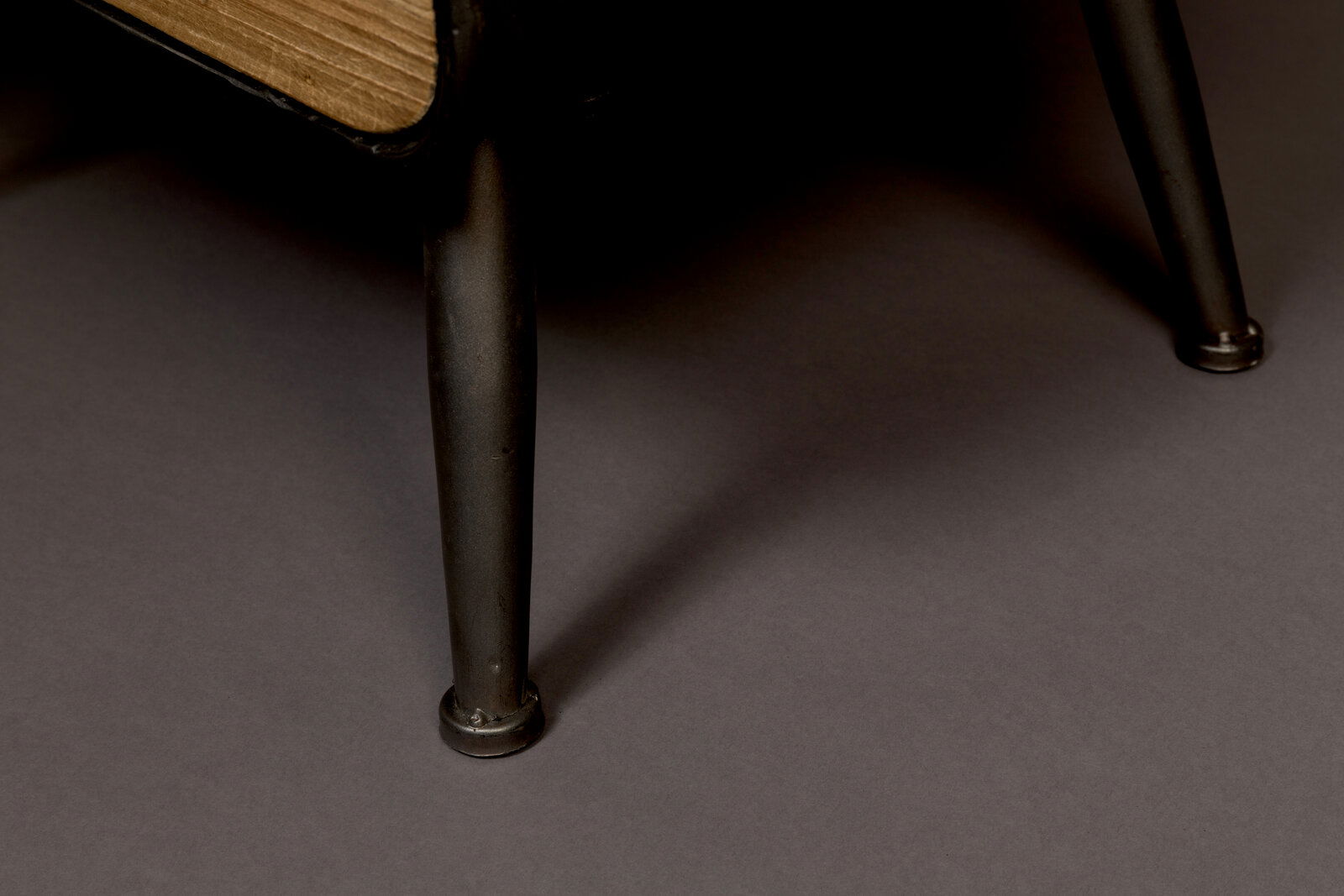 Nahaufnahme eines Weinregals mit Metallbeinen und Holzdetails, seitliche Perspektive