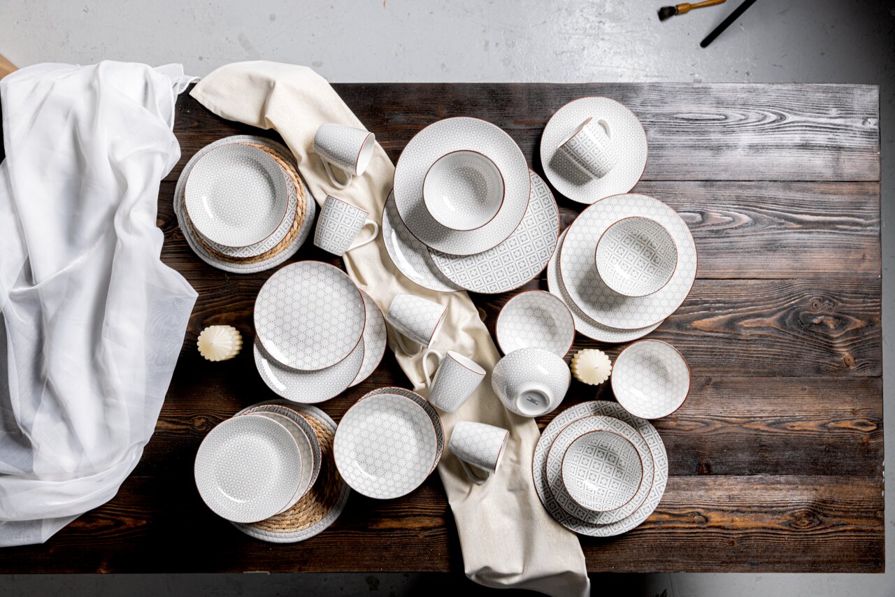 Kombiservice 30-teilig mit elegantem Muster, von oben fotografiert auf einem Holztisch arrangiert.