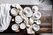 Kombiservice 30-teilig mit elegantem Muster, von oben fotografiert auf einem Holztisch arrangiert.