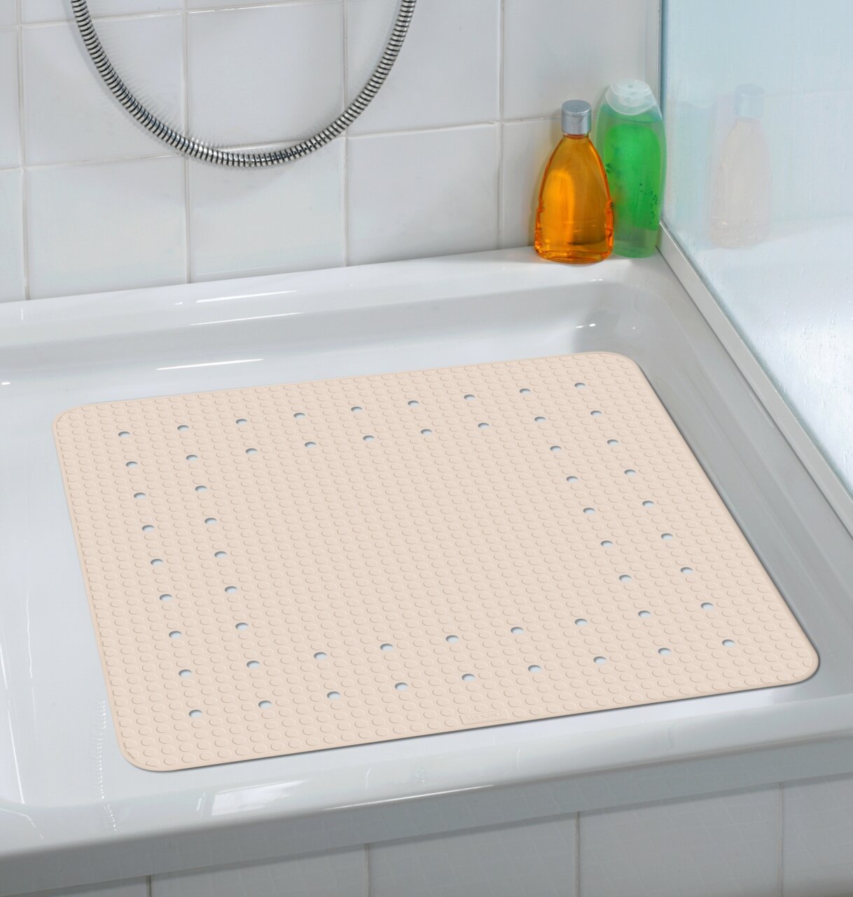 Beige Duscheinlage Mirasol in einer Duschwanne, von oben fotografiert, mit rutschfester Oberfläche und Abflusslöchern.
