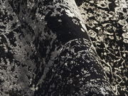 Nahaufnahme eines Designer-Teppichs mit abstraktem, schwarz-weißem Muster in einer gewellten Perspektive.