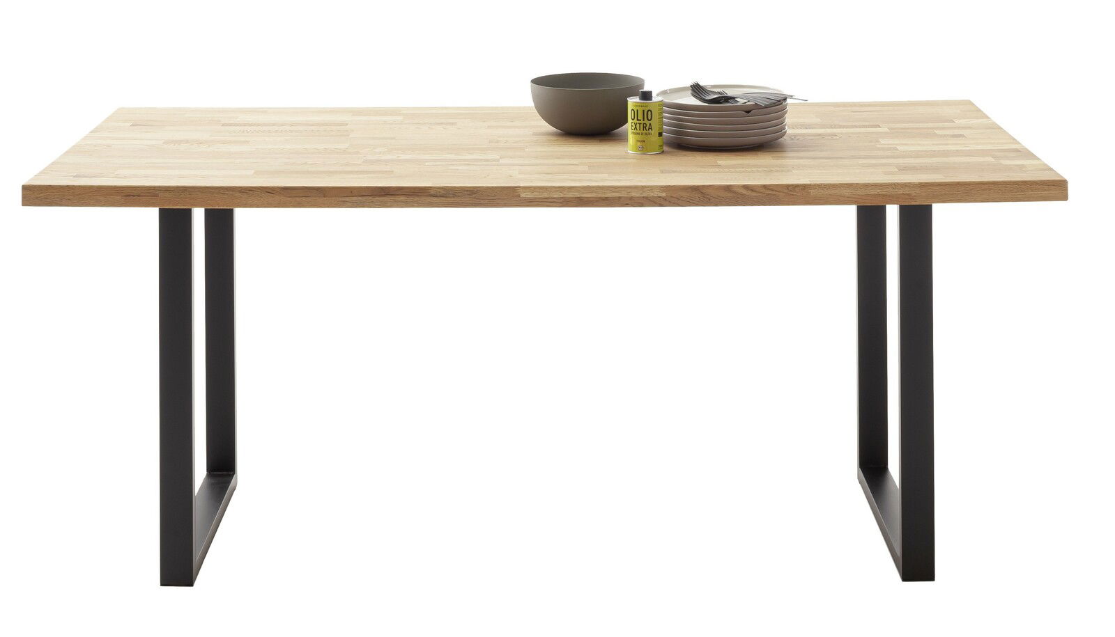 Moderner Esstisch mit Holzplatte und schwarzen Metallbeinen, frontal fotografiert. Auf dem Tisch stehen eine Schüssel, ein Stapel Teller und eine Ölflasche.
