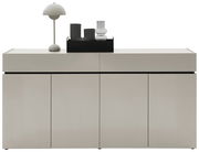 Moderner XXL-Schuhschrank in minimalistischer Frontansicht mit Dekorationen auf der Oberseite, darunter eine Lampe und Glasobjekte.