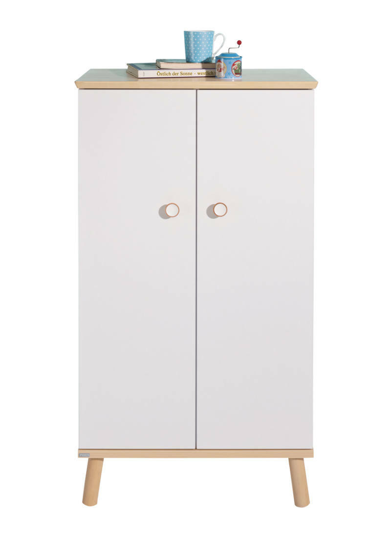 Frontansicht eines weißen Standregals mit zwei Türen, Holzbeinen und einer Ablagefläche mit Büchern und einer Tasse.